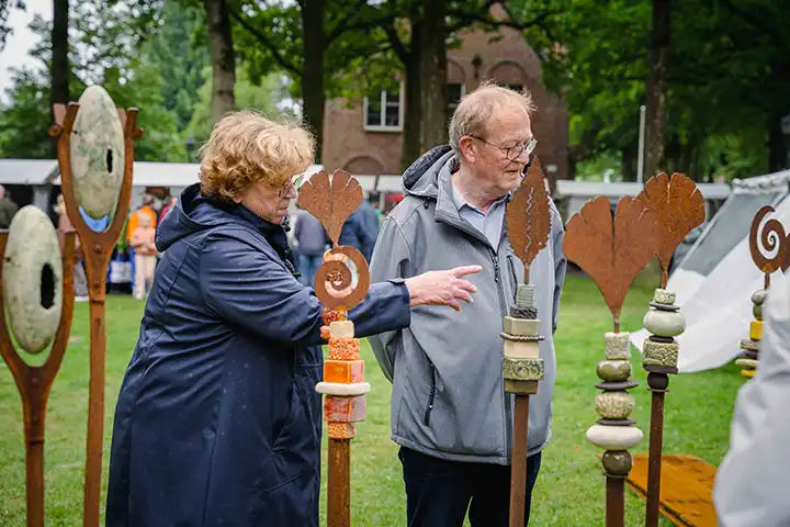 Bezoekers bekijken keramiek onder eeuwenoude bomen van de Brink